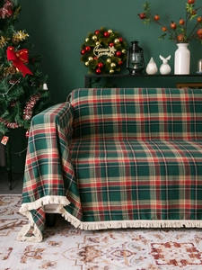 Detail of red and green plaid Christmas throw blanket featuring white fringe tassels