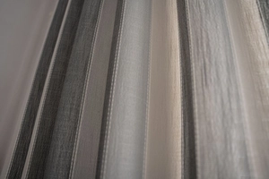 Close-up of striped cotton-linen blend fabric texture with thick grey and beige vertical patterns