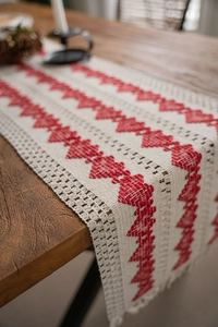 Detail of cotton linen table runner with red heart embroidery and crochet lace edges