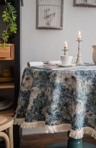 Macro detail of retro blue floral jacquard round tablecloth with beige tassel fringe