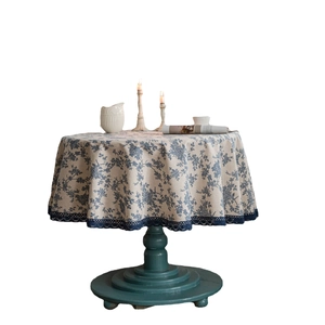 Blue rose print round linen tablecloth with elegant lace trim in a vintage home setting