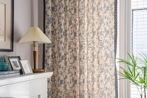 Detail of blue floral print cotton linen curtain with vintage hollow lace edge