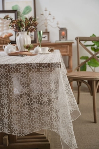 Detailed view of white floral lace tablecloth featuring elegant scalloped edge design