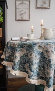 Detailed view of floral jacquard round tablecloth with beige fringe edges