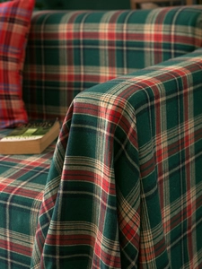 Close-up of vintage red and green plaid cotton blanket with soft woven texture details