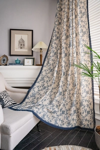 Close-up of vintage blue floral linen curtains featuring elegant hollow lace edge trim