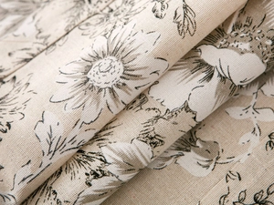 Detailed macro view of linen fabric showing texture and black sunflower print pattern