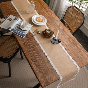 Rustic jute table runner with white lace edges on a dark wood dining table setup