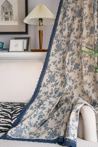Detail of blue floral cotton linen curtain featuring elegant navy crochet lace trim