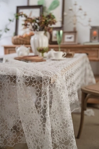 Macro shot of white lace tablecloth edge with vintage floral embroidery details