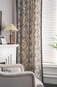 Detail of blue floral cotton linen curtain with dark blue lace trim and vintage pattern
