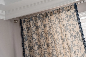 Close-up of blue floral cotton linen curtain with exquisite lace edges and embroidery