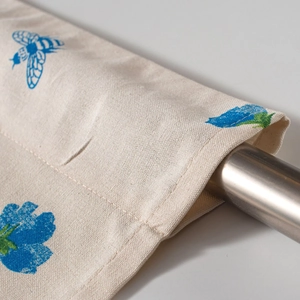 Detail der Stangentasche am Tulpen-Bistrovorhang mit blauem Bienen-Blumenmuster auf Leinen