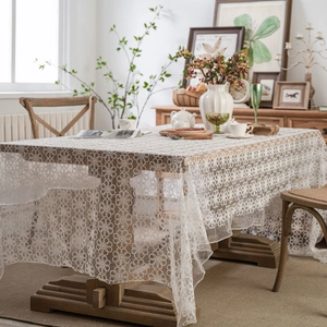 White lace floral tablecloth with vintage hollow embroidery on a wooden dining table