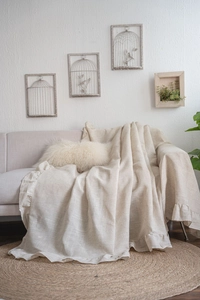 Detail of ruffle edges and natural linen texture on a minimalist sofa cover cloth