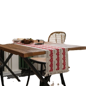 Cotton linen table runner with red heart woven patterns and fringe on wooden table