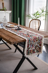 Detailed close-up of bohemian geometric jacquard table runner with white fringe edges