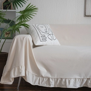 Creamy white sofa cover with ruffles and a minimalist abstract face line art pillow
