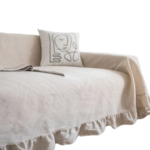 Minimalist beige sofa cover with ruffled edges and linen texture in modern home setting