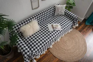 Detail of black and white gingham sofa throw with ruffle edges in a Nordic home setting
