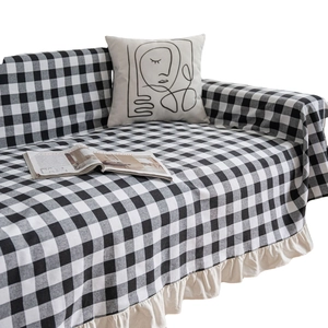 Classic black and white checkered sofa cover with elegant cream ruffled edge detail