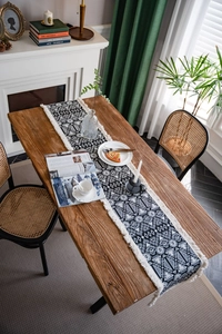 Detailed close-up of geometric jacquard patterns and handmade tassels on cotton table runner