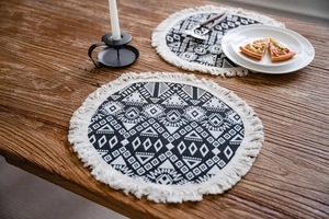 Detail of round boho table placemats with geometric patterns and fringe tassels
