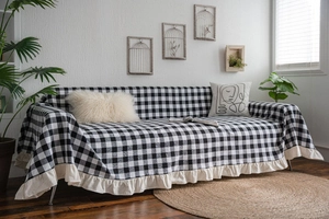 Close-up of black and white plaid sofa cover with cream ruffled edge detail