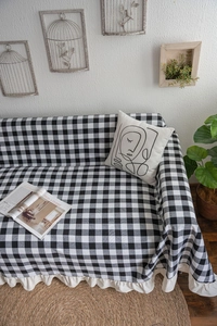 Close-up of black and white checkered sofa cover with elegant ruffled edge detail