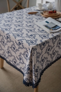 Close-up of navy blue floral cotton linen tablecloth with crochet lace border decoration