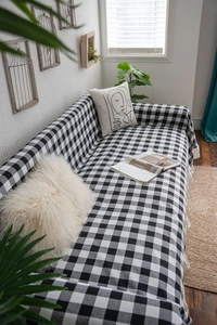 Detail of black and white gingham sofa throw cover with elegant ruffled edges and woven texture