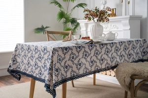 Linen tablecloth with navy floral print and intricate crochet lace border in garden style