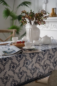 Detailed view of the navy blue floral linen tablecloth featuring exquisite black lace edges