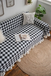 Detailed close-up of a black and white gingham sofa cover with stylish ruffled edges