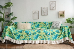 Close-up of floral sofa cover with white ruffle edges in a cozy home setting
