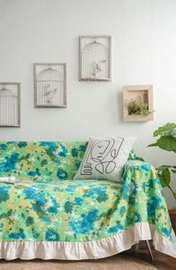 Detailed view of the ruffle edge and green camo marble pattern sofa cover fabric