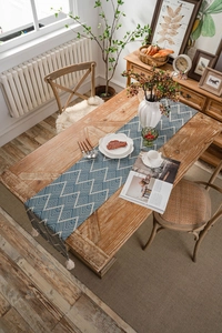 Close-up of geometric blue and white jacquard table runner with delicate white tassels