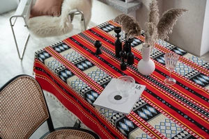 Dettaglio della tovaglia in lino bohémien rossa con motivi geometrici e frange
