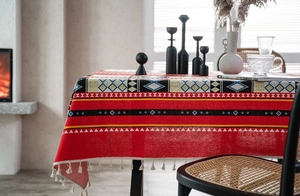 Dettaglio della tovaglia boho rossa in cotone e lino con motivi geometrici e nappe
