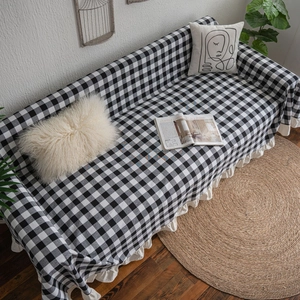 Classic black and white checkered sofa cover with elegant white ruffled edges for living room