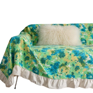 Floral textured sofa cover in green blue yellow tones with elegant white ruffle hem edge