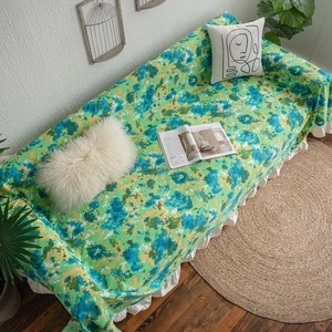 Green camouflage print sofa cover with white ruffle edges in a Nordic home setting