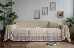 Detail of bohemian cream crochet sofa throw featuring geometric hollow mesh and long tassels