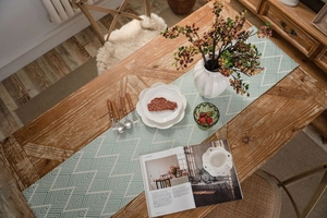 Detailed close-up of mint green geometric jacquard table runner with a chic tassel fringe
