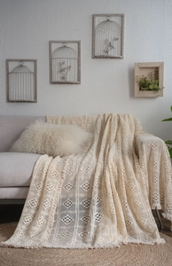 Detailed macro view of beige crochet hollow lace cotton sofa cover with fringe edges