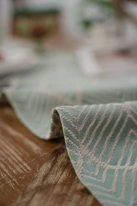 Detailed view of Nordic geometric jacquard table runner with fringe and green patterns