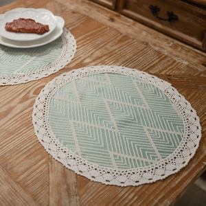 Nordic green geometric jacquard table placemat with lace edges on a dark wooden surface
