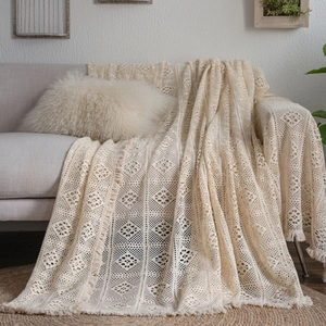 Beige boho crochet sofa throw with floral hollow patterns and tassel fringe detail