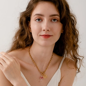 Collana a catena in oro 18 carati con pendenti a fungo e sole indossata da modella