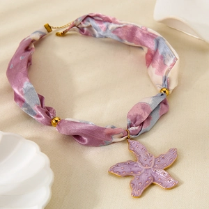Ciondolo a stella marina in oro 18 carati su collana in nastro di seta viola stampato